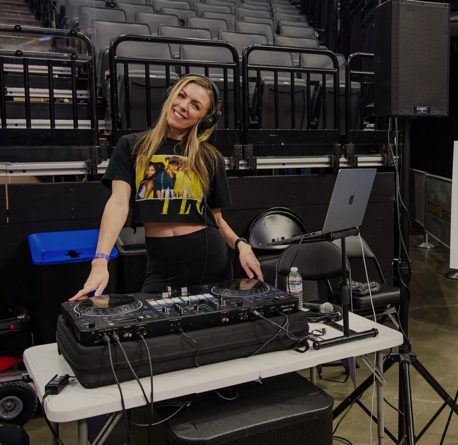 DJ Lyndsay Brown smiling over her controller at an arena event